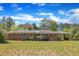 Rear exterior view of the home showcasing brick architecture, deck, and carport at 1213 Walnut St, Cary, NC 27511