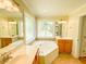 Bright bathroom with soaking tub under a decorative window and double vanity at 122 American Rd, Timberlake, NC 27583
