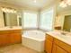 Bathroom with soaking tub under a decorative window and double sink vanity at 122 American Rd, Timberlake, NC 27583