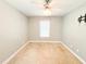 Neutral bedroom featuring tan carpet, ceiling fan with light fixture, and window providing natural light at 122 American Rd, Timberlake, NC 27583