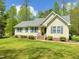 Inviting single-story home showcasing a pristine lawn, mature trees, and stylish blue shutters at 122 American Rd, Timberlake, NC 27583