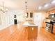 Open kitchen with an island, hardwood floors, stainless appliances and access to the living room at 122 American Rd, Timberlake, NC 27583