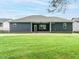 View of the house's blue siding and a spacious, green lawn with a covered patio perfect for outdoor activities at 125 Claymore Dr, Clayton, NC 27527