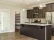 Kitchen island with dark cabinets, light countertops, stainless appliances, and a walk-in pantry at 125 Claymore Dr, Clayton, NC 27527