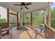 Covered wooden back deck is furnished with several chairs, overhead fan, and wooded views at 128 Waterleaf Pl, Clayton, NC 27527