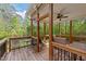 Covered deck with wooded views featuring ceiling fan, outdoor seating, and wooden railing at 128 Waterleaf Pl, Clayton, NC 27527