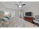 Carpeted bedroom features a ceiling fan, a large window, and a dresser with a television at 128 Waterleaf Pl, Clayton, NC 27527