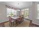 Dining room with wood table, six chairs, large windows, and access to the deck at 128 Waterleaf Pl, Clayton, NC 27527