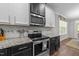 Close up view of kitchen featuring stainless steel oven, microwave, subway tile backsplash at 128 Waterleaf Pl, Clayton, NC 27527