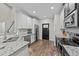 Kitchen with stainless appliances, tile backsplash, granite counters, access to black pantry door at 128 Waterleaf Pl, Clayton, NC 27527