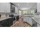 Well-lit kitchen features granite countertops, stainless appliances and white and black cabinets at 128 Waterleaf Pl, Clayton, NC 27527