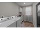 Functional laundry room with washer, dryer, utility sink, cabinets, and window at 128 Waterleaf Pl, Clayton, NC 27527