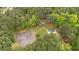 An aerial shot showcasing the tennis court, pool, and verdant expanse of lush trees at 1368 Ohio Ln, Sanford, NC 27332
