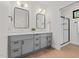 Bright bathroom featuring a double vanity with grey cabinetry and a glass-enclosed shower at 1368 Ohio Ln, Sanford, NC 27332