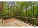 Wood deck features a wood and metal wire railing and view of the surrounding trees at 1368 Ohio Ln, Sanford, NC 27332
