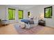 Serene main bedroom featuring large windows with wooded views, plush bedding, and a cozy seating area at 1368 Ohio Ln, Sanford, NC 27332
