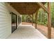 Concrete patio space beneath a deck with view of the wooded backyard at 1368 Ohio Ln, Sanford, NC 27332