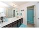 Bright bathroom featuring a large mirror, vanity with dark wood cabinets, and a shower with a turquoise curtain at 140 Torrey Heights Ln, Durham, NC 27703