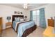 Bedroom with blue and brown bedding set, a ceiling fan, window with curtains and side tables at 140 Torrey Heights Ln, Durham, NC 27703