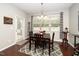Cozy dining area with a dark wood table, decorative chandelier, and large windows providing natural light at 140 Torrey Heights Ln, Durham, NC 27703