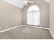 A cozy bedroom features neutral carpet, a ceiling fan, and an arched window letting in natural light at 1454 Spring Pond Rd, Nashville, NC 27856
