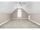 A cozy bedroom features neutral carpet, a ceiling fan, and an arched window letting in natural light at 1454 Spring Pond Rd, Nashville, NC 27856