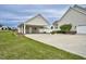 Detached garage with white columns, beige siding, oversized driveway, and green grass at 1454 Spring Pond Rd, Nashville, NC 27856