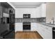 Contemporary kitchen with white cabinets, granite counters, and modern black appliances at 1454 Spring Pond Rd, Nashville, NC 27856