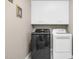 Laundry room featuring updated washer and dryer and white storage cabinets at 1454 Spring Pond Rd, Nashville, NC 27856
