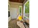 Charming porch featuring wood floors, a yellow rocking chair, and a small black accent table at 1521 Providence Glen Dr # 1521, Chapel Hill, NC 27514