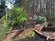 Landscaped backyard featuring a wooden deck and mature trees, offering a serene outdoor space at 158 Randolph Dr, Clayton, NC 27520