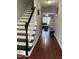 Hallway with wood floors and painted black-and-white stairs at 158 Randolph Dr, Clayton, NC 27520