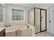 Well-lit bathroom boasts soaking tub, glass door shower, and neutral tones, creating a spa-like feel at 1602 Eagle Lodge Ln, Durham, NC 27703