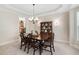 Well-lit dining room with a wood table, upholstered chairs, and china cabinet at 1602 Eagle Lodge Ln, Durham, NC 27703