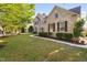 Well-manicured front yard showcasing a brick two-story home with manicured bushes and fresh green lawn at 1602 Eagle Lodge Ln, Durham, NC 27703