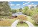Aerial view showcasing the brick home, circular driveway, and lush surrounding landscape at 1750 Spring Valley Lake Rd, Henderson, NC 27537