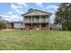 Two-story home with a brick facade, a spacious lawn, and a charming back porch at 1750 Spring Valley Lake Rd, Henderson, NC 27537
