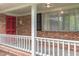 Welcoming front porch with brick siding, white railing, and a bright red front door at 1750 Spring Valley Lake Rd, Henderson, NC 27537