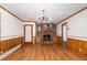 Cozy living room with a brick fireplace, built-in cabinets, wood paneling, and laminate floors at 1750 Spring Valley Lake Rd, Henderson, NC 27537