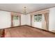 Large living room featuring neutral carpet, classic curtains, and natural light from the windows at 1750 Spring Valley Lake Rd, Henderson, NC 27537