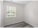 Bright bedroom with modern gray floors and a view of the backyard through a window at 1808 Elkpark Dr, Raleigh, NC 27610