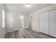 A bright bedroom boasts wood floors, white walls, and closet with an en-suite bathroom at 1808 Elkpark Dr, Raleigh, NC 27610