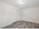 A modern bedroom features gray wood floors, neutral paint, and a large closet with white folding doors at 1808 Elkpark Dr, Raleigh, NC 27610