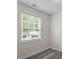 Bright bedroom with modern gray floors and a window with a view of the neighborhood at 1808 Elkpark Dr, Raleigh, NC 27610