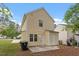 The rear of this charming yellow home shows a fenced in yard, small patio, and lush landscaping at 1808 Elkpark Dr, Raleigh, NC 27610