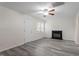 Bright living room featuring stylish gray floors, a cozy fireplace, and a ceiling fan at 1808 Elkpark Dr, Raleigh, NC 27610