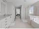 Bathroom featuring a soaking tub, glass enclosed shower, and dual vanities at 1911 Firenza Dr, Apex, NC 27502