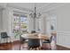 Bright dining room featuring hardwood floors, a modern chandelier, and large window for natural light at 1911 Firenza Dr, Apex, NC 27502