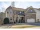 Attractive two-story brick home featuring an attached two-car garage and manicured front lawn at 1911 Firenza Dr, Apex, NC 27502