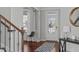 Bright foyer featuring hardwood floors, a staircase, a decorative rug, and neutral paint at 1911 Firenza Dr, Apex, NC 27502